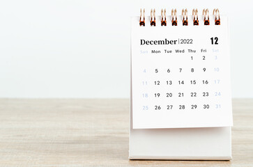 December 2022 desk calendar on wooden background.