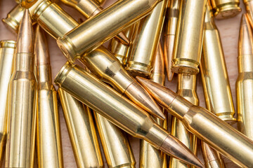 A scattering of cartridges with 7.62 caliber bullets for the Kalashnikov assault rifle, close-up, selective focusing. Concept: sale of weapons under lend-lease, assistance with ammunition, supply of w