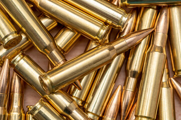 A scattering of cartridges with 7.62 caliber bullets for the Kalashnikov assault rifle, close-up, selective focusing. Concept: sale of weapons under lend-lease, assistance with ammunition, supply of w