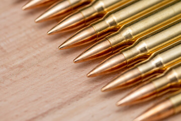 A row of cartridges with 7.62 caliber bullets for a Kalashnikov assault rifle on a textured...
