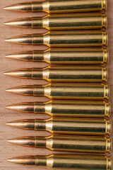 A row of cartridges with 7.62 caliber bullets for a Kalashnikov assault rifle on a textured...