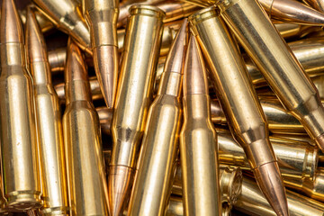 A scattering of cartridges with 7.62 caliber bullets for the Kalashnikov assault rifle, close-up, selective focusing. Concept: sale of weapons under lend-lease, assistance with ammunition, supply of w