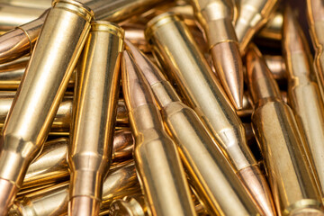 A scattering of cartridges with 7.62 caliber bullets for the Kalashnikov assault rifle, close-up, selective focusing. Concept: sale of weapons under lend-lease, assistance with ammunition, supply of w