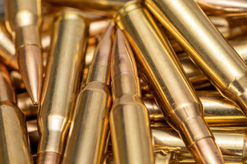A scattering of cartridges with 7.62 caliber bullets for the Kalashnikov assault rifle, close-up, selective focusing. Concept: sale of weapons under lend-lease, assistance with ammunition, supply of w