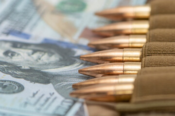 Cartridges with bullets in a bandolier, dollar bills. close-up. Concept: sale of weapons under...