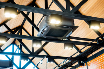 Ceiling type 4 directions air conditioner  venting system unit in a modern coffeeshop with ambience lighting