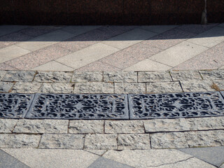Storm drain in stone tiles. Urban environment.