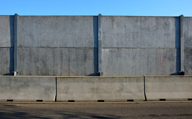 soundproof wall made of concrete porous ribbed material. fence of gray blocks embedded in metal...