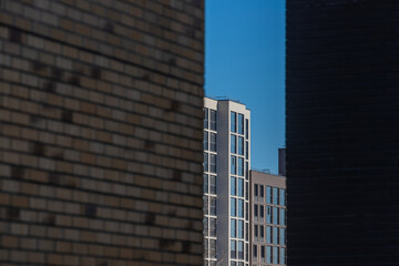 View of a multi-storey high-rise residential building in the metropolis through a brick wall of black  
