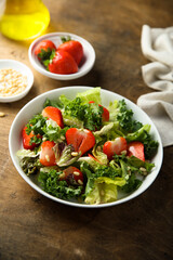 Fototapeta na wymiar Healthy green salad with strawberry and pine nuts