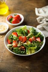 Healthy green salad with strawberry and pine nuts