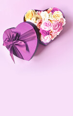 Heart shape gift box and bouquet. Flowers a gift in the shape of a heart. Roses in a box heart on pink background.