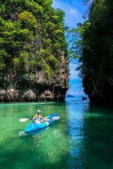 Woman on kayak in calm tropical lagoon on Koh Hong island