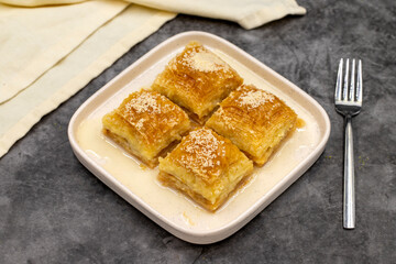 Milk baklava. Baklava with hazelnuts on a dark background. Mediterranean cuisine delicacies. Close-up. local name sutlu nuriye baklava