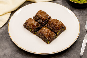 Chocolate baklava. Chocolate baklava with pistachio on dark background. Mediterranean cuisine delicacies. Close-up. local name cikolatali baklava