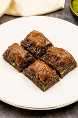 Chocolate baklava. Chocolate baklava with pistachio on dark background. Mediterranean cuisine delicacies. Close-up. local name cikolatali baklava