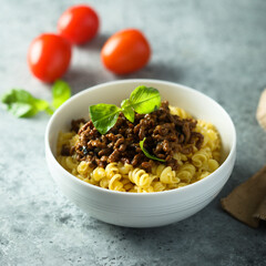 Pasta with minced meat and green basil