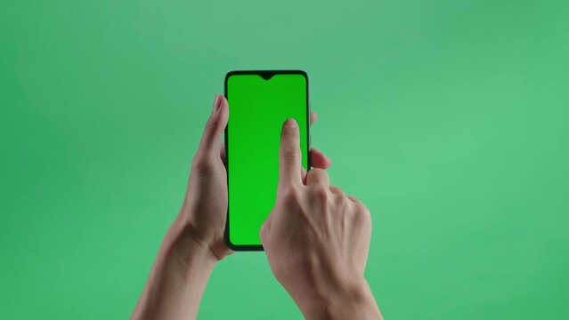 A Hand Touching Green Screen Smartphone On The Green Screen Background
