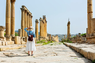 sian young woman tourist in color dress and hat enjoying the Oval Forum in ancient Roman city...