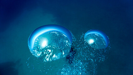 Artistic underwater photography of air bubbles going up to the surface