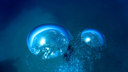 Air bubble going up against the surface underwater