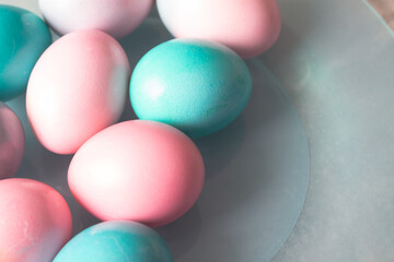 Light pink and turquoise, blue eggs on a blue plate and a gray background for the Easter holiday