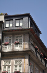 Obraz premium Parte de fachada de prédios antigos de cidade europeia, vasos de flores nas varandas, condomínios, habitações antigas