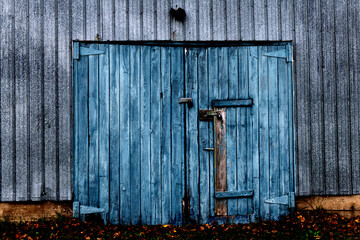 A blue barn door in a gray wall