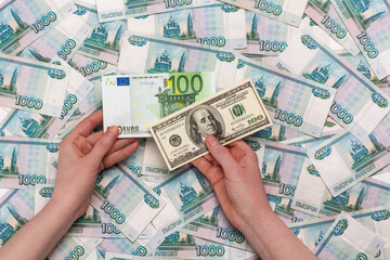 US Dollar and Euro holding in hand on Russian ruble background.