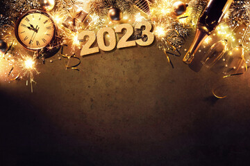 New Years Eve 2023 holiday background with fir branches, clock, christmas balls, champagne bottle,...
