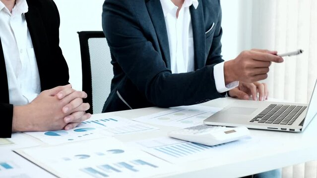 Business meeting, Businessman is summarizing financial graphs and analyzing market trends from a laptop to develop a company's revenue, Brainstorming or Discussing concept.