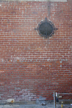 vintage brick wall with portal window and decorative iron © Heidi Patricola