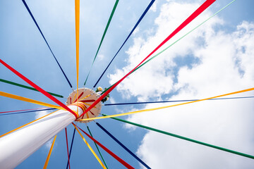 Low angle shot of a pole with colored ribbons on a traditional English Maypole dancing day - obrazy, fototapety, plakaty