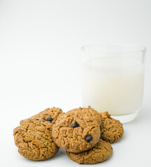 Chocolate chip cookies and glass of milk on white background