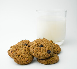 Chocolate chip cookies and glass of milk on white background