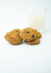 Chocolate chip cookies and glass of milk on white background