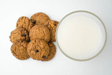 Chocolate chip cookies and glass of milk on white background