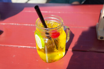 refreshing drink in glass jar with lemon slice and cherry. italian soda