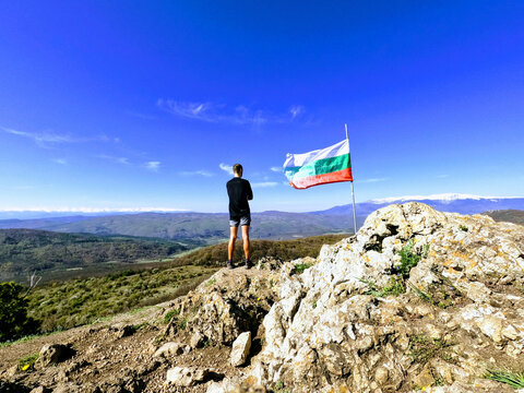 Traveler and the flag of Bulgaria in Polovrak peak, Lozen