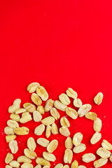 Heap of roasted and salted peanuts isolated on a red background