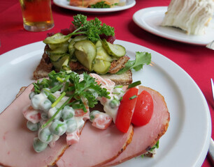 Two open-face Danish sandwiches: pork and sliced meatball
