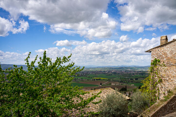 Fototapeta na wymiar Panoramic wide view of the countryside surrounding the medieval village of Assisi, in springtime (Umbria, central Italy). It's world famous as the city of St. Francis.