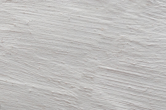 The background is in the form of gray rough plaster on the wall, whitewashed with chalk. Plaster tecture close-up.