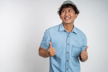 asian young man showing thumbs up with smiling teeth on isolated background