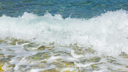 Fototapeta premium Sea wave and pebble. Summer vacation concept. Sea wave with foam incident on the coastal shingle. Travel concept