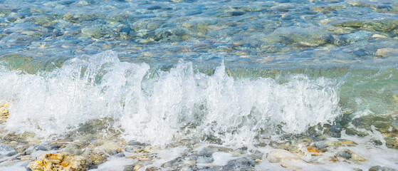 Sea wave and pebble. Summer vacation concept. Sea wave with foam incident on the coastal shingle. Travel concept