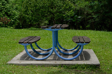 Small table with benches on green land in Kepong Metropolitan Park, Kuala Lumpur, Malaysia