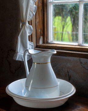 Jug In The Bowls Against A Window Inside A Pioneer Cottage In Rai Valley, New Zealand
