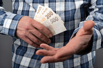 Counting Czech koruna in various nominal banknotes CZK. Hold a small cash money on hand. Czechia...