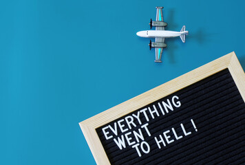 Toy passenger plane next to a felt board that says everything went to hell. The concept of...